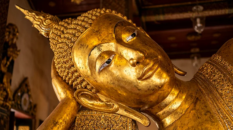 Close detail of golden Reclining Buddha's face and shoulder section at Wat Pho